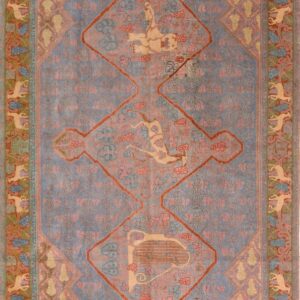 A muted gray-blue rug features a central diamond medallion with a stylized gold harp and pink floral patterns.