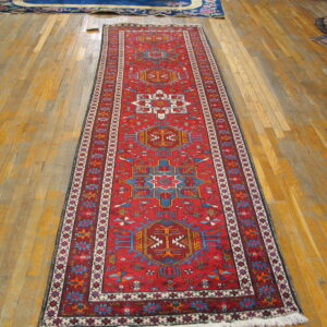 Vibrant red Karajeh runner rug on a wooden floor
