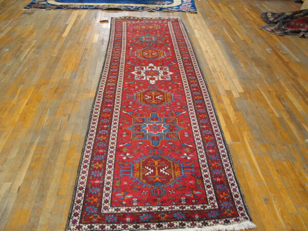 Vibrant red karajeh runner rug on a wooden floor
