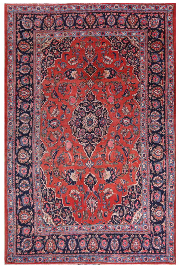 Red field rug with a central medallion and elaborate floral vine patterns, framed by a wide navy border.