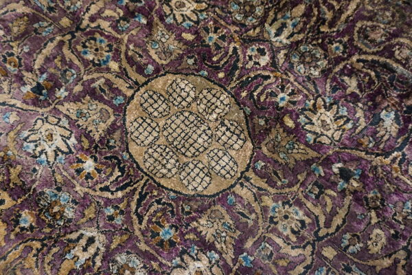 Velvety traditional rug close-up in purple, tan, and blue with an intricate central medallion design.