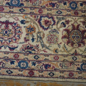 Textured, high-pile rug with blue, burgundy, and cream traditional floral patterns visible on wood flooring.