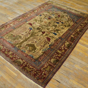 Beige rug featuring a detailed Tree of Life design and deep maroon border on worn wood flooring.