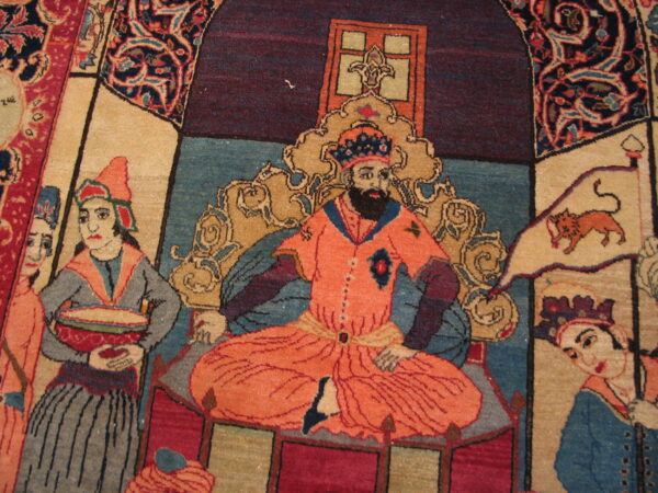 Pictorial rug featuring figures in salmon, blue, and cream, framed by deep burgundy and elaborate floral borders.