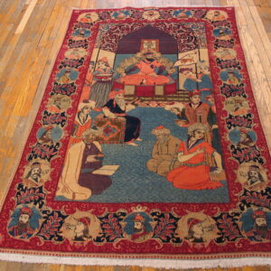 Red and blue pictorial rug with a central court scene and portrait borders on hardwood floors.