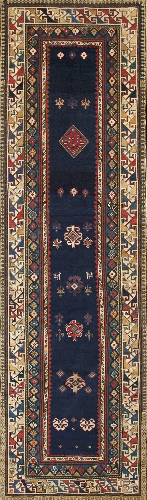 Narrow navy runner rug displaying traditional geometric symbols surrounded by complex multicolored borders.