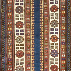 Deep blue runner rug with alternating stripes of geometric borders and cream panels containing red medallions.