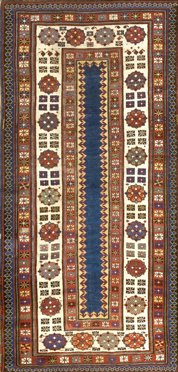 Deep blue runner rug with alternating stripes of geometric borders and cream panels containing red medallions.