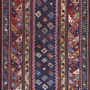 Geometric runner rug with a navy blue center panel and complex red, tan, and blue tribal borders.