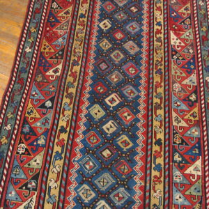 Red, blue, and yellow runner with geometric patterns centered on a polished hardwood floor.