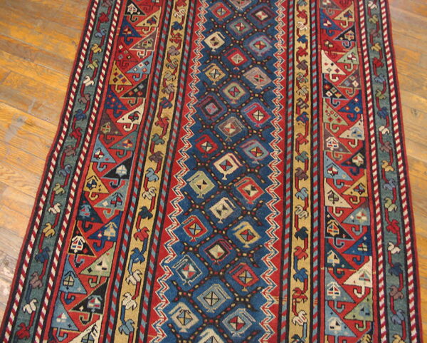Red, blue, and yellow runner with geometric patterns centered on a polished hardwood floor.