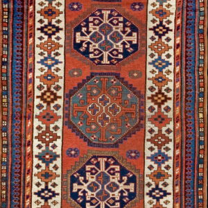Vertical geometric runner rug in rust, navy, gold, and cream with repeating central tribal medallions.