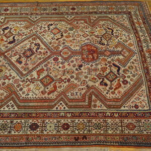 Geometric tribal rug in red, blue, and cream colors rests on light golden wooden floorboards.