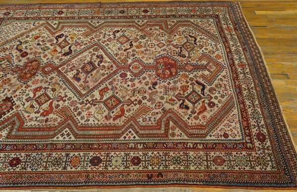 Geometric tribal rug in red, blue, and cream colors rests on light golden wooden floorboards.