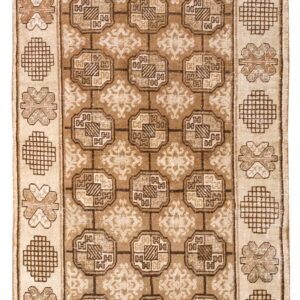 Beige and brown rug with a grid of octagonal medallions and alternating geometric shapes in the border.