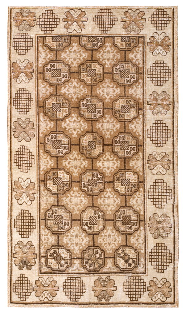 Beige and brown rug with a grid of octagonal medallions and alternating geometric shapes in the border.