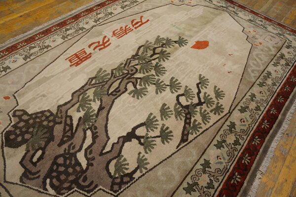 A beige rug features a large brown tree design, red chinese characters, and detailed red and green borders.