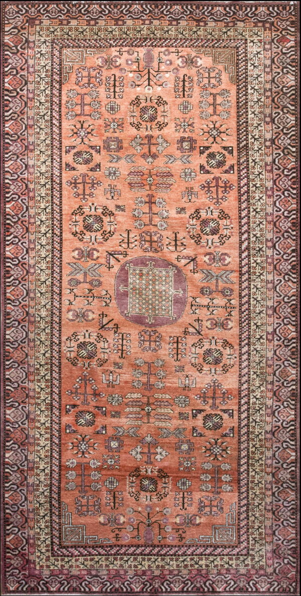 Terracotta runner rug featuring geometric tribal symbols and a central medallion in burgundy, beige, and dark brown.