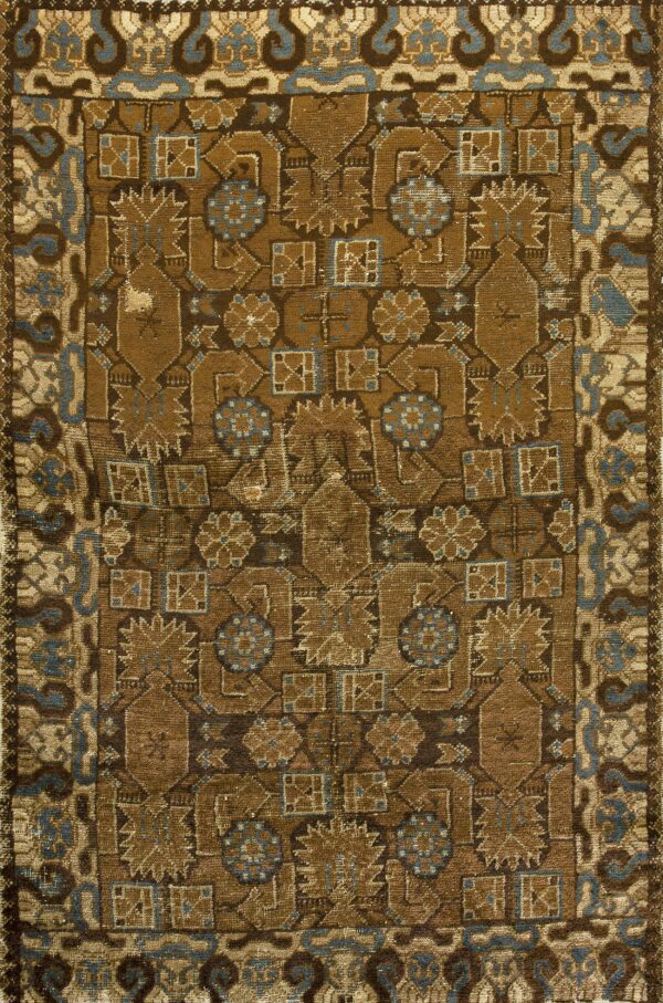 Earth-toned rug with a dense geometric pattern in shades of brown accented by dusty blue.