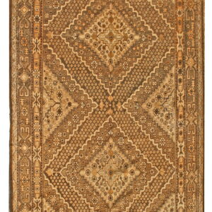 A traditional brown and tan rug with stepped geometric diamond patterns and complex borders.