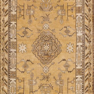 A mustard yellow rug featuring a central medallion and stylized motifs in dark brown and tan.