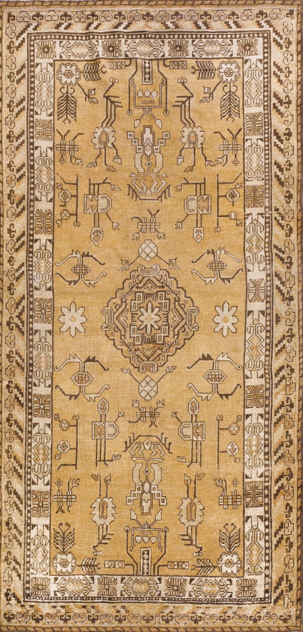 A mustard yellow rug featuring a central medallion and stylized motifs in dark brown and tan.
