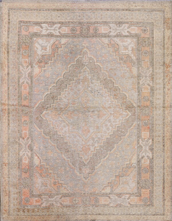 Muted rug with a central geometric diamond motif and layered borders in dusty gray, coral, and cream.