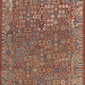 Muted red runner rug features dense stylized motifs and geometric borders in blue, cream, and rust.