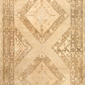 Geometric diamond medallion rug in faded beige and brown tones with extensive patterned borders.