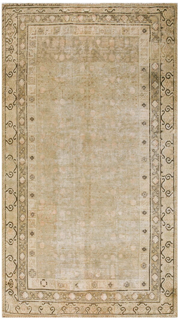 Faded oriental-style rug in muted green and beige with detailed geometric and floral borders.