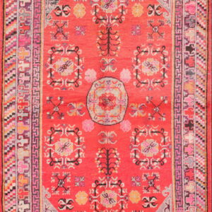 Vibrant red high-pile rug with a detailed floral pattern and multiple geometric borders in pink, gray, and yellow.