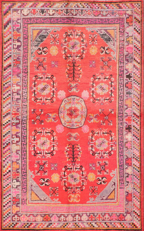 Vibrant red high-pile rug with a detailed floral pattern and multiple geometric borders in pink, gray, and yellow.
