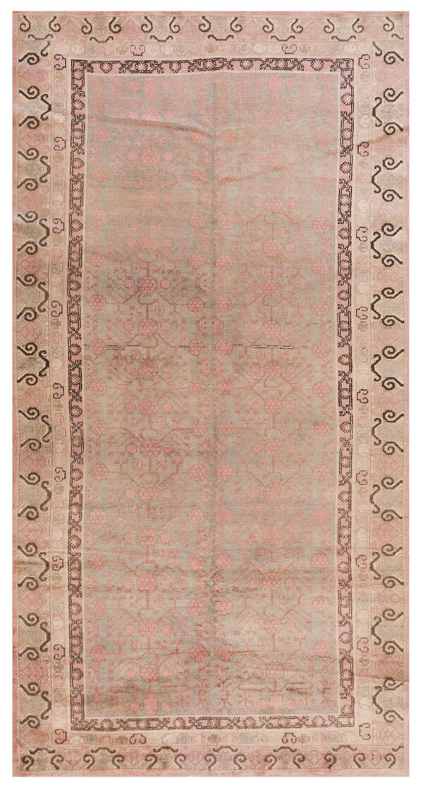 Faded sage rug with dusty pink floral motifs and multi-striped borders featuring dark swirling designs.