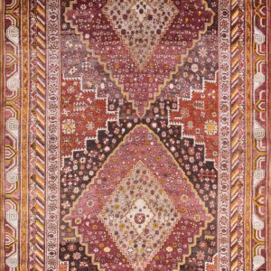 Traditional rug with a large stepped diamond pattern in deep red, rust, and beige tones.