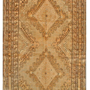 Geometric rug with large diamond medallions and detailed borders in faded ochre, brown, and pale gray.