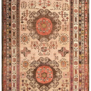 Beige rug with two large brown and rust geometric medallions and multiple detailed borders.