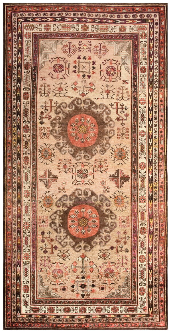 Beige rug with two large brown and rust geometric medallions and multiple detailed borders.