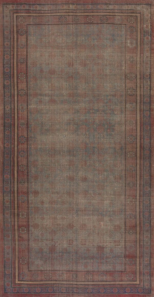 Rectangular distressed rug in muted blue and red tones with an ornate floral border.