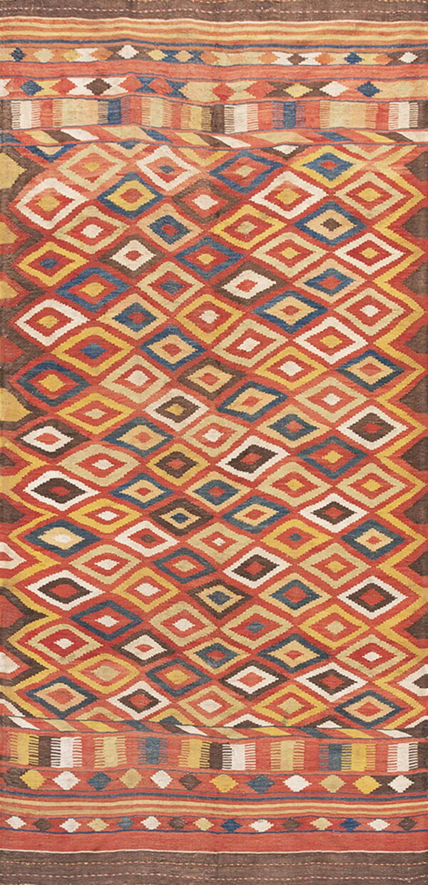 A flat-woven rug with a central pattern of stacked red, yellow, blue, and brown diamonds and striped borders.