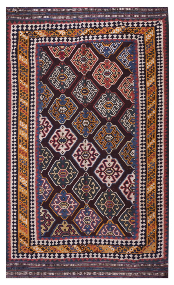 Low-pile rug with a dark field, repeating multicolored geometric diamond medallions, and striped borders.