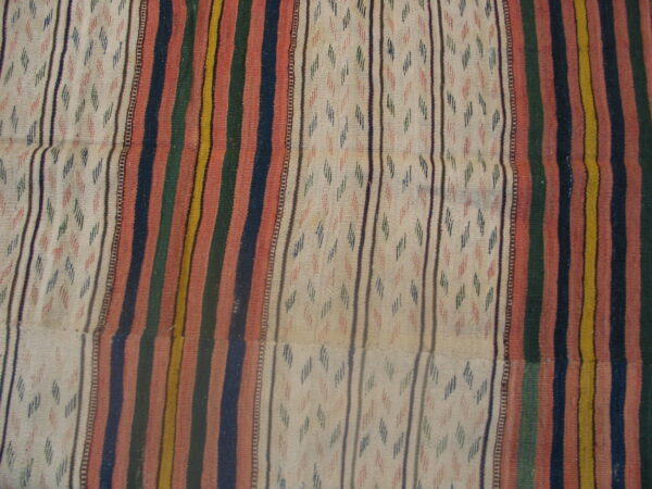 Flat woven rug with alternating vertical stripes of varied colors and patterned cream sections.