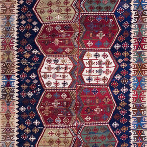 Detailed geometric rug with a navy background and alternating red, green, blue, and white polygonal medallions.