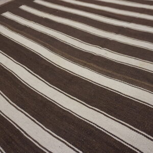 Flatweave rug with broad horizontal stripes in dark brown and contrasting off-white colors.