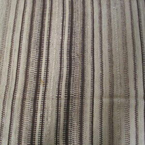 Flat-woven textile features vertical stripes in alternating natural light and dark brown tones.