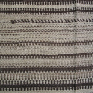 Textured flatweave rug in natural beige and dark brown, featuring alternating horizontal striped and dotted patterns.