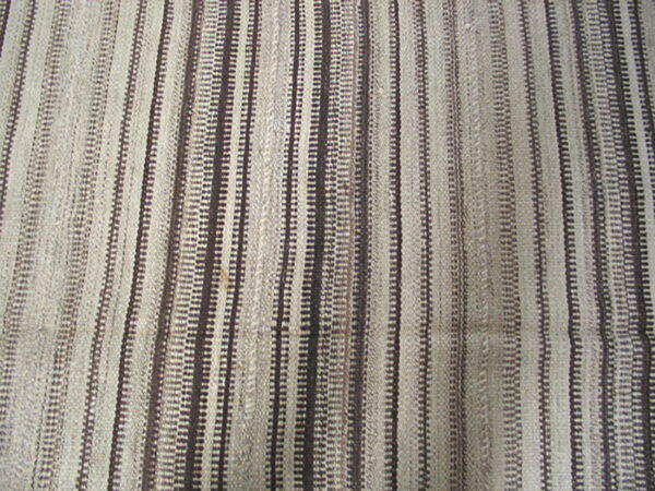 Textured flatweave rug with thin vertical stripes in shades of off-white, beige, and dark brown.