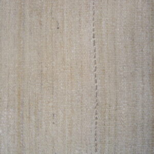 Detailed view of a heathered oatmeal flatweave texture with a central vertical stitched seam.