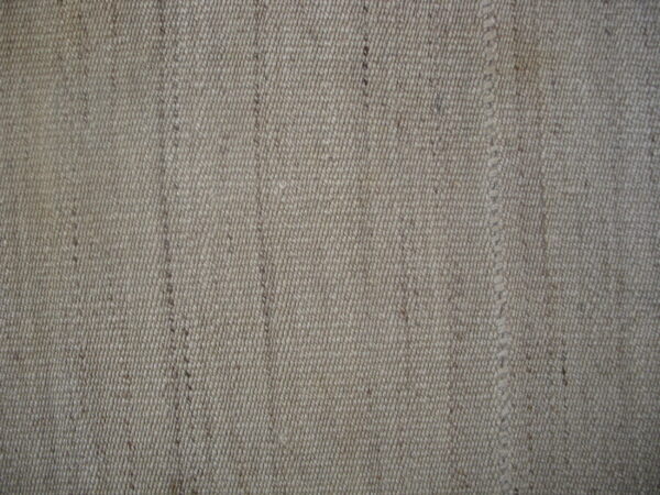 Close-up texture of a natural beige woven rug with vertical striations and visible stitching.