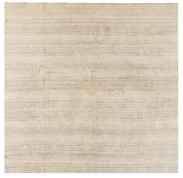 A textured light beige flatweave rug features subtle horizontal striping in varying shades of tan on a white background.