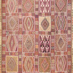 Flatweave rug with a grid of tribal geometric squares containing diamond patterns in rose, cream, and maroon.